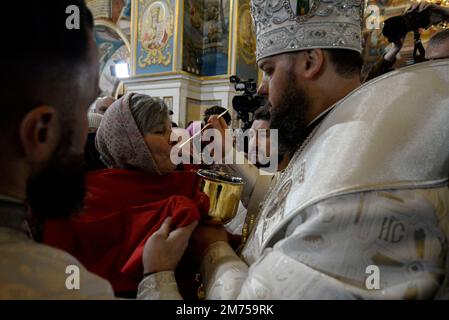 Kyiv, Ukraine. 7th Jan, 2023. A woman receives communion from a priest at a Christmas service held by the Orthodox Church of Ukraine in Uspenskyi Cathedral. It is the first time in history of the Orthodox Church of Ukraine, that it holds a service in Kyiv-Pechersk lavra, which was rented for many years by a sect of the Russian orthodox Church. (Credit Image: © Danylo Antoniuk/ZUMA Press Wire) Stock Photo