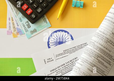 KYIV, UKRAINE - MAY 4, 2022 Indian income tax return blank form with pen and indian rupees bills on indian country flag close up. Annual tax report concept Stock Photo