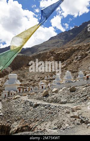 Small white stupa on the mountainside, prayer flags in front, Hunder Gompa, Leh District, Nubra Tehsil, Ladakh, India Stock Photo