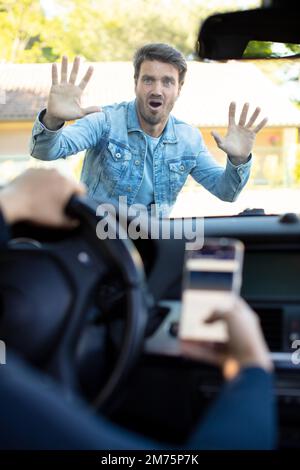 a driver using his phone runs over a pedestrian Stock Photo