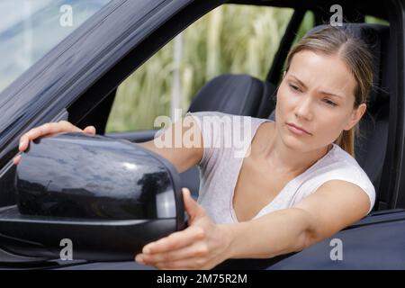 mans hand corrects the side-view mirror in the car Stock Photo