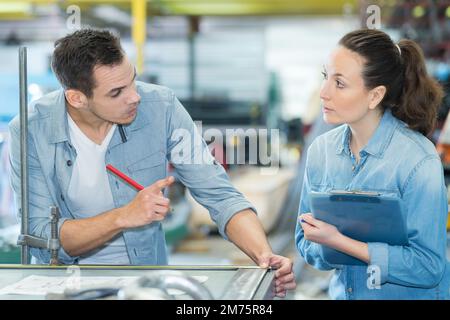 two workers discussing project in factory Stock Photo