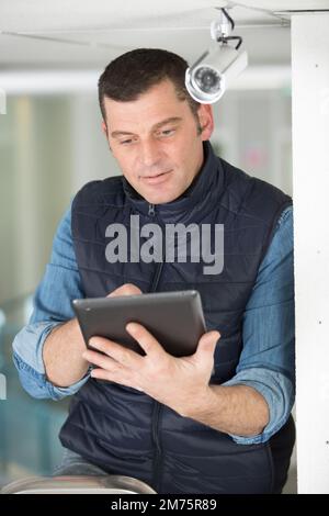 maintenance man by cctv camera holding tablet Stock Photo