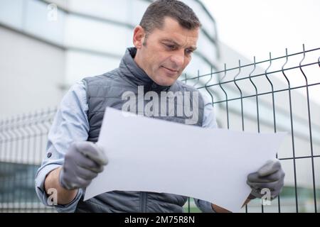 architect or engineer holding looking project blueprint papers Stock Photo