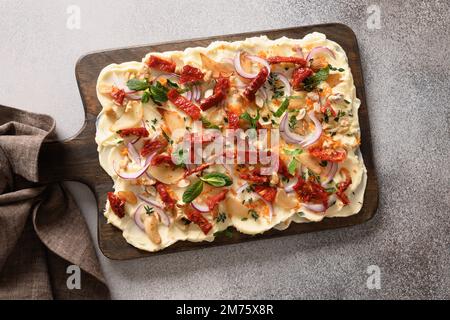 Popular Butterboard with onion, garlic, sun-dried tomatoes, thyme on gray background. View from above. Stock Photo