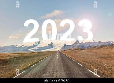 The word 2023 is written behind a glacier and an empty asphalt road Stock Photo