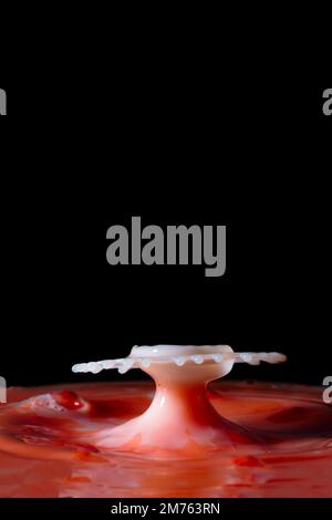 figure of mushroom and crater created by colliding water drops on a background of red water photography of water drops Stock Photo