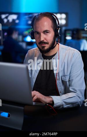 Vertical Portrait looking at camera of a Stock Market Trader Working Investment Charts, Graphs. Financial Analyst and Digital Business man in a Busy Stock Photo