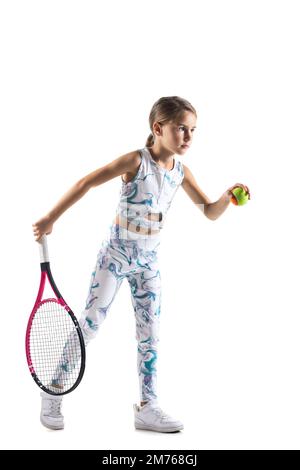 Young female tennis player. Little girl posing with racket and ball isolated on white background. Stock Photo