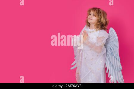 Angel prayer. Angel child. Isolated studio shot. Cute kid with angel wings. Cupid with prayer hands, hope and pray concept, valentines day concept Stock Photo