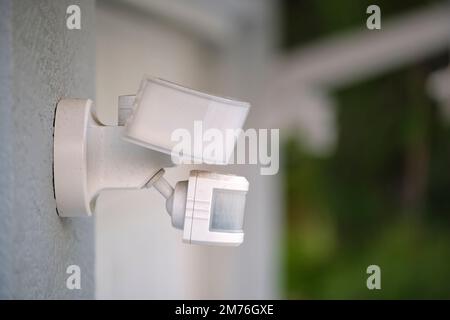 Motion sensor with light detector mounted on exterior wall of private house as part of security system Stock Photo
