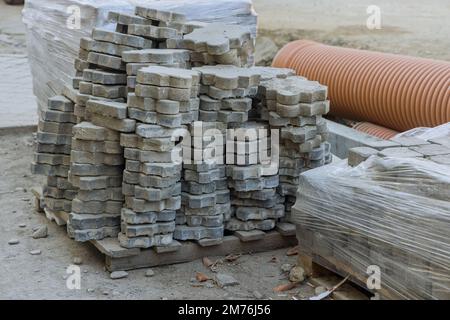 Construction works landscape paver installation laying gray concrete bricks on sidewalk Stock Photo