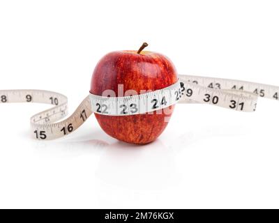Measuring up the progress. Studio shot of a red apple with measuring tape wrapped around it. Stock Photo