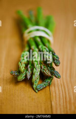 Tender and ready to eat. a bunch of green asparagus tied up with string. Stock Photo