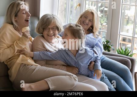 Cheerful female relatives having fun on home couch Stock Photo