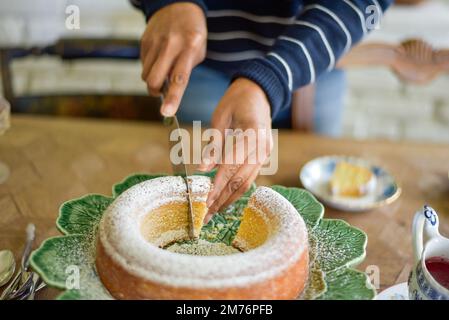 woman slicing a sponge cake Stock Photo