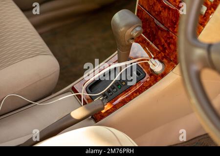 12V charger in a vehicle for charging electrical devices on the go Stock Photo
