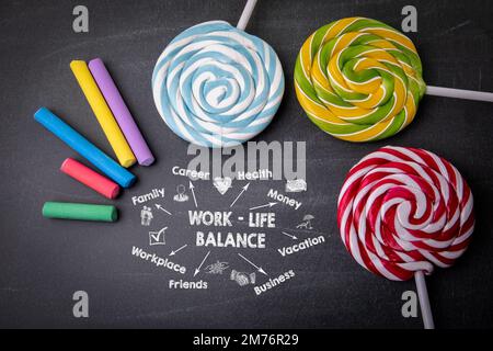 Work Life Balance concept. Colored pieces of chalk and candy lollipop. Stock Photo