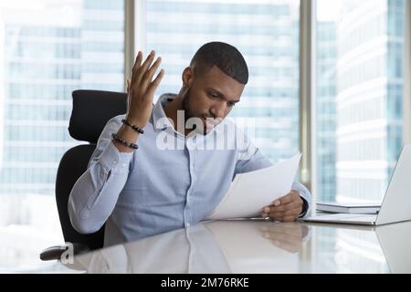 Frustrated African man read bad news in postal letter Stock Photo