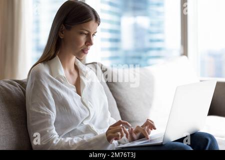 Attractive young woman working or studying using laptop Stock Photo