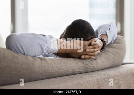 Unknown African single man relaxing leaned on sofa, closeup Stock Photo