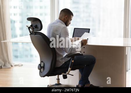 African sales manager, financial reviewing statistical data at workplace Stock Photo
