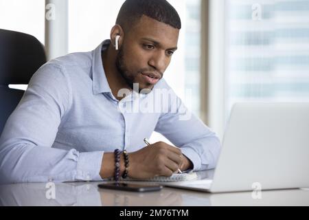 African man e-learning sit at desk with laptop Stock Photo