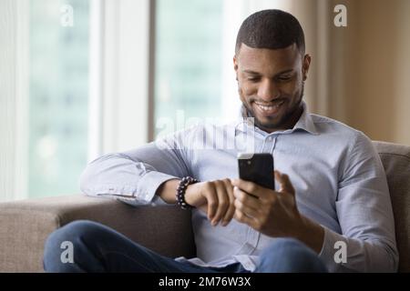 Handsome African man using modern smart phone Stock Photo