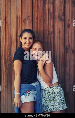 Together we could conquer the world. To young girls holding each other affectionately. Stock Photo