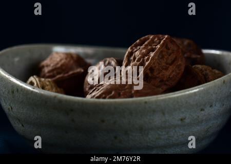 Close up of fresh wallnuts on a dark background; shallow depth of field Stock Photo