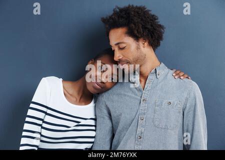 So happy together. Portrait of a happy and affectionate young couple on a gray background. Stock Photo