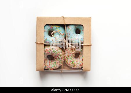 White and Blue sprinkled glazed donuts packed in box isolated on white background, natural light Stock Photo