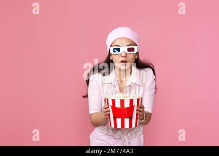 woman watching movie film, holding bucket of popcorn Stock Photo