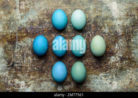 Happy Easter rustic concept. DIY dyed various shades of blue Easter eggs on retro rusty metal background. Stock Photo