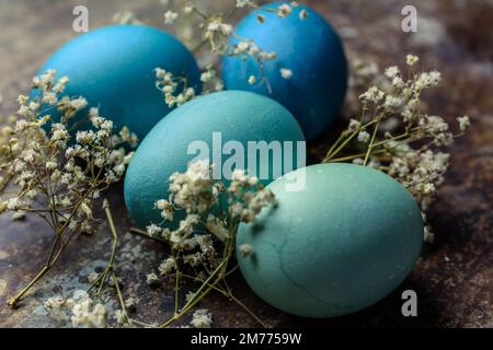 Happy Easter rustic concept. DIY dyed various shades of blue Easter eggs on retro rusty metal background. Stock Photo