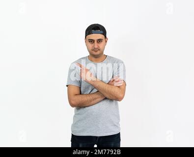 Close up studio photo of young adult brown skinned man finger pointing for copy space or space for text. Stock Photo