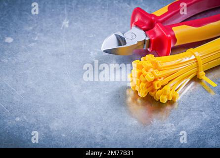 Nippers plastic zip cable ties on metallic background construction concept. Stock Photo