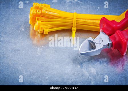 Nippers cable ties on metallic background construction concept. Stock Photo