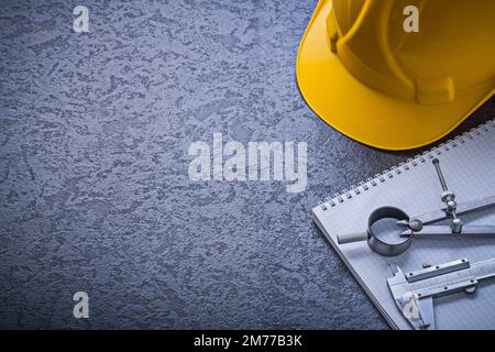 Notebook hard hat divider vernier scale copyspace construction concept. Stock Photo