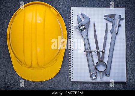 Adjustable wrench notebook on black background construction concept ...