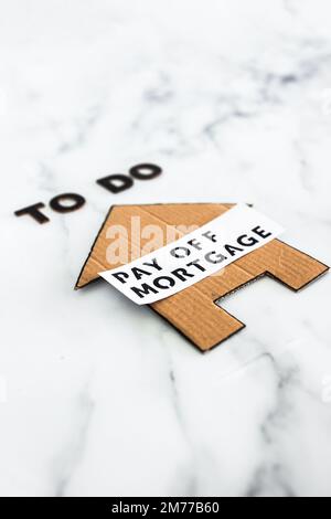 To Do Pay Off Mortgage text with cardboard house, concept of financial independence and being free from debt Stock Photo