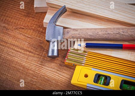 Pencil wooden meter and bricks construction level claw hammer on vintage wood board maintenance concept. Stock Photo