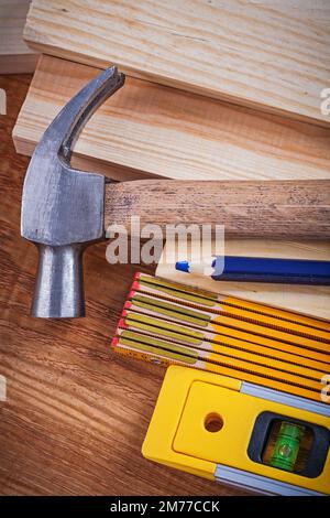 Pencil wooden meter and bricks construction level claw hammer on vintage wood board close up image maintenance concept. Stock Photo