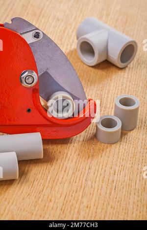 pipe cutter and polypropylene cutted pipes on wooden boards Stock Photo