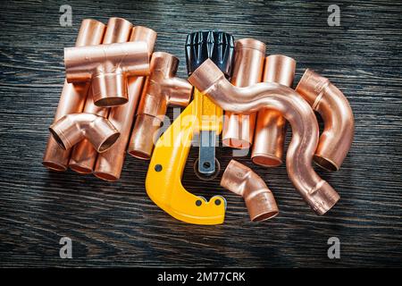 Plumbing copper water pipe cutter on wooden board. Stock Photo
