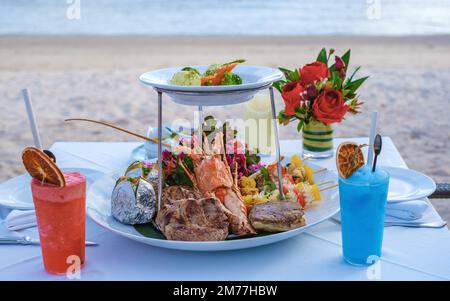 dinner on the beach with lobster and cocktails.  Stock Photo