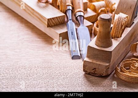 veri close up view old fashioned plane chisels planks shavings on wooden board Stock Photo