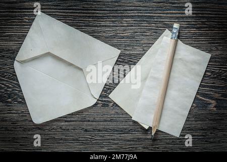 Vintage envelope blank paper sheet pencil on black board. Stock Photo