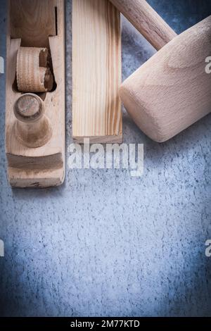 Wooden shaving plane hammer stud on metallic background construction concept. Stock Photo