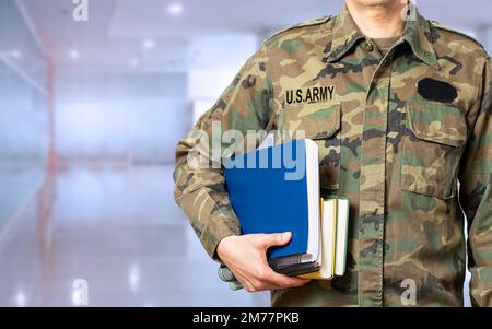 Soldier with books in hand and ready to go back to the academy as a student and copy space Stock Photo